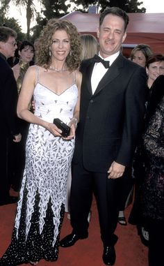 a man in a tuxedo standing next to a woman