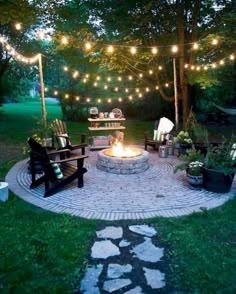 an outdoor fire pit with lights strung over it