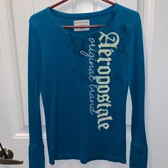 Aeropostale Brand New W/Out Tags Long Sleeved Women’s T Shirt In Size Xl! Loving This Teal Blue Color With The White Design On The Front. Aeropostale Sets, Vintage Aeropostale, Aeropostale Graphic Tees Women, Aeropostale Hoodies, Aeropostale Long Sleeve Shirts, Aeropostale Shirts, Teal Blue Color, Sleeves (women), Aeropostale