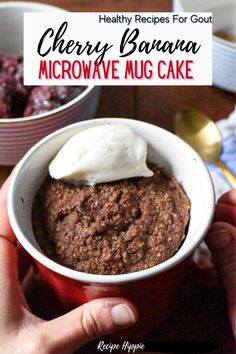 a person holding a bowl of microwave mug cake with whipped cream on top and the words cherry banana microwave mug cake above it