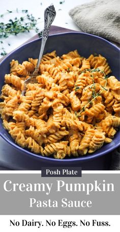 creamy pumpkin pasta sauce in a blue bowl with a spoon