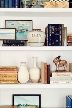 the shelves are filled with books and vases for sale on instagram, as well as photos