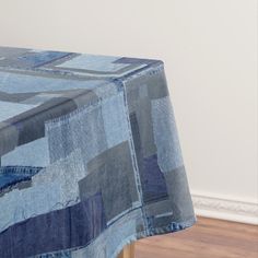 a blue table cloth with patchwork designs on it and a wooden chair in the background