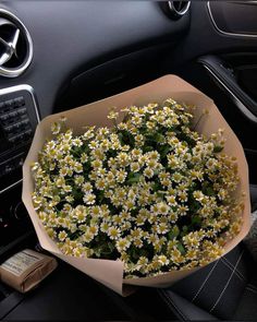 a bouquet of daisies in the center of a car