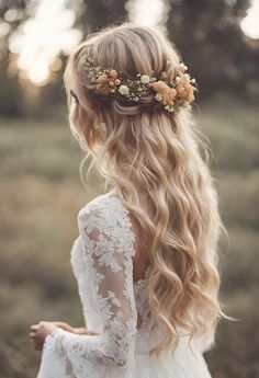 a woman with long blonde hair and flowers in her hair, wearing a white dress