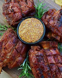 several pieces of meat on a cutting board with dipping sauce