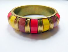 Chunky and very colorful cuff bracelet! The base is made of gold tone metal and it is adored with red, yellow and brown colored plastic pieces, making this a very bright and funky piece of jewelry! Size (approximately):  Diameter 6.5 cm / 2.5 inches Cuff width 2 cm / 0.8 inch Want to see more cool vintage bracelets? Check here: https://etsy.me/40kU8Vz All items have been professionally cleaned. If necessary small repairs have been made. Subscribe to my newsletter for deals, ideas and discount co Handmade Multicolor Metal Bangle, Red Bohemian Metal Bangle, Red Metal Bohemian Bangle, Bohemian Red Metal Bangle, Retro Multicolor Bangle Jewelry, Retro Gold Bangle For Gift, Retro Gold Bangle As Gift, Retro Gold Bangle As A Gift, Retro Multicolor Bangle Bracelets