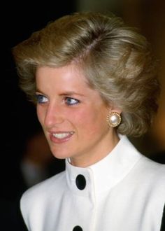 the princess of wales smiles as she wears her hair in a bun