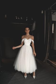 a woman in a white dress posing for the camera