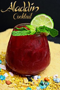 a drink in a glass sitting on top of a table next to corn and lime