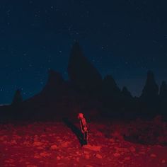 a person standing in the middle of a field at night