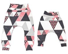 two baby leggings with pink and black triangles on them