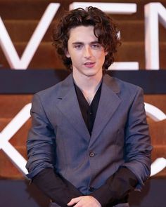 a young man in a suit and tie posing for the camera