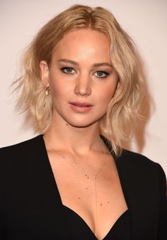 a close up of a person wearing a black shirt and posing for the camera with her hands in her pockets