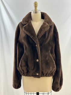 This 80s brown faux fur jacket is one of a kind. In a bomber style, it buttons up the front, has an elastic waist, pockets.  a great collar and is super cozy. Pair this with flared jeans or oversized joggers. -Vintage 80s  -Bomber style, faux fur -Professional fur cleaner recommended  Measurements:  I am a size 38d, 34 waist, 40 hips and this fit me well, can be an oversized fit also *Sleeve 22 1/2 inches *Bust 21  inches *Length 22 inches from shoulder *Bottom 17 inches *Please note this item i Cozy Brown Outerwear With Button Closure, Brown Winter Fur Coat With Button Closure, Winter Brown Fur Coat With Pockets, Brown Faux Fur Outerwear With Pockets, Cozy Brown Long Sleeve Fur Coat, Brown Fur Coat With Button Closure For Fall, Brown Fur Coat With Buttons For Fall, Brown Long Sleeve Fur Coat With Faux Fur Trim, Brown Fur Coat With Faux Fur Lining