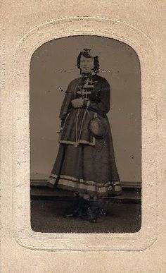 an old black and white photo of a woman in a long dress holding a basket