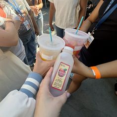 several people are holding cups with drinks in them and straws sticking out of them