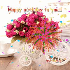 a birthday card with pink flowers in a white basket next to a coffee cup and saucer