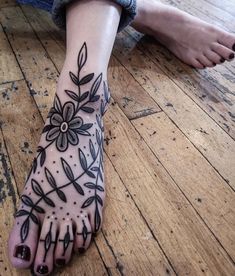 a woman's foot with tattoos on it