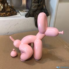 a large pink toy laying on top of a table next to a busturine