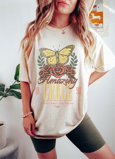 "Amazing Grace Comfort Colors Oversized Vintage T-Shirt, Christian God Shirt, Jesus Shirt, Jesus Comfort Colors Shirt, Jesus Shirt Aesthetic Whether you're hitting the road for a cross-country adventure or just hanging out with friends, you'll love its comfortable, oversized fit with this Comfort Colors shirt. The mineral wash feel is super soft and perfect for any casual occasion. Rock this tee with your favorite jeans or leggings and you'll look great no matter what. This is a standard unisex size Comfort Colors Tee. For an oversized tee, please size up. If you are looking for an oversized \"T-shirt Dress\" look, we recommend sizing up 2 sizes. Please review the size chart to ensure you receive the fit you want. HOW TO ORDER 1- Select \"Shirt Size\". 2- Select quantity. 3- Click \"Add To Western Graphic Tees, Country Music Shirts, Comfort Colors Tshirt, Hippie Shirt, Cowgirl Shirts, Country Shirts, Cow Girl, Comfort Colors Tee, Nashville Tennessee