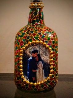 a glass bottle with a photo in the bottom and lights around it, on top of a table