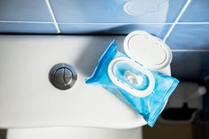 a blue bag sitting on top of a white toilet