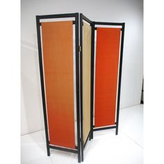 an orange and black room divider sitting on top of a white floor