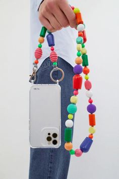 a person holding a cell phone and beaded necklace