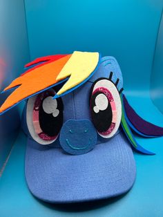 Custom made Rainbow Dash hat inspired from MLP. Adjustable adult size. Made from a cotton-poly blend, felt and other craft items. Hand painted sparkly detail to eyes.  Made to order.  Adjustable hat size from 17-24 inches, or 43-61 cm. Velcro closure Laundering information: recommend carefully spot cleaning with gentle cleanser if soiled Apple Jack, Gentle Cleanser, Rainbow Dash, Craft Items, Adjustable Hat, Hat Sizes, Trucker Cap, My Little Pony, Caps Hats