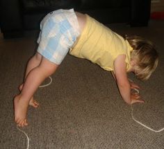 a small child is playing with a wii controller on the floor in front of a couch