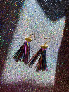 Gift yourself or a friend a unique set of rainbow metallic tinsel tassel earrings for a special occasion. They feature 18K gold and a tinsel fringe that dangle perfectly from your ears for a festive look. Upgrade any outfit for a holiday party, New Year’s Eve, or any special event! Materials: 18K gold hook, gold half moon, tinsel fringe Fringe Length: 3in Tinsel Tassel, Party New Year, New Year’s Eve, Fringe Earrings, Tassel Earrings, Half Moon, Custom Items, Holiday Party, Custom Clothes