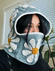 a woman wearing a crocheted hood with flowers on it