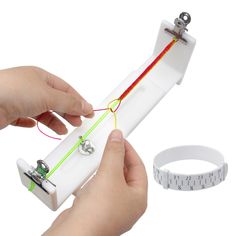 a person is holding an electronic device in their hand and measuring it with a tape