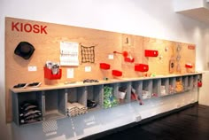 a room with several shelves and bins on the wall that have knosk written on them