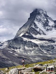 a man is running in front of a mountain