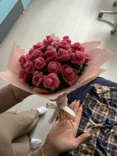 a person holding a bouquet of pink flowers