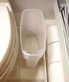 a white toilet sitting in a bathroom next to a trash can