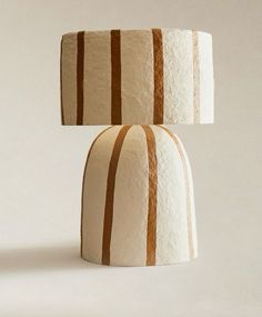 two white and brown striped lamps sitting next to each other