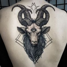 the back of a woman's upper body with a goat head tattoo