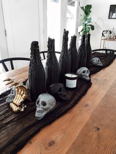 a table topped with black vases filled with skulls and skulls sitting on top of it