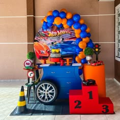 an ice cream cart decorated with balloons and decorations for a hot wheels birthday party on display