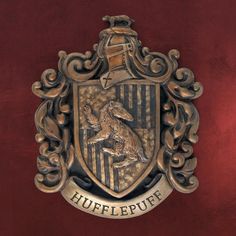 an emblem on the side of a red wall that says,'hufflepuff '