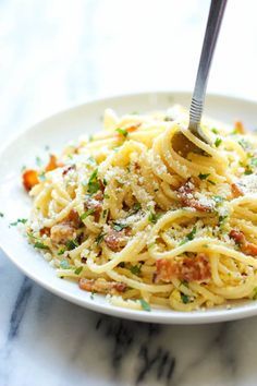 a plate of spaghetti with meat and parmesan cheese