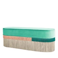 an upholstered bench with fringe trims on the top and bottom, in teal green velvet