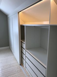 an empty white closet with drawers and shelves