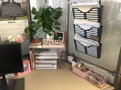 an office cubicle with desk, computer and bookshelf filled with papers on it