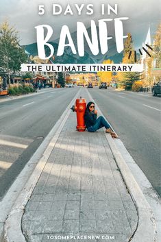 a woman laying on the side of a road next to a red fire hydrant