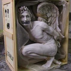 a white statue sitting inside of a wooden box