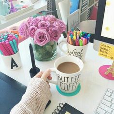 a person is sitting at a desk with a cup of coffee